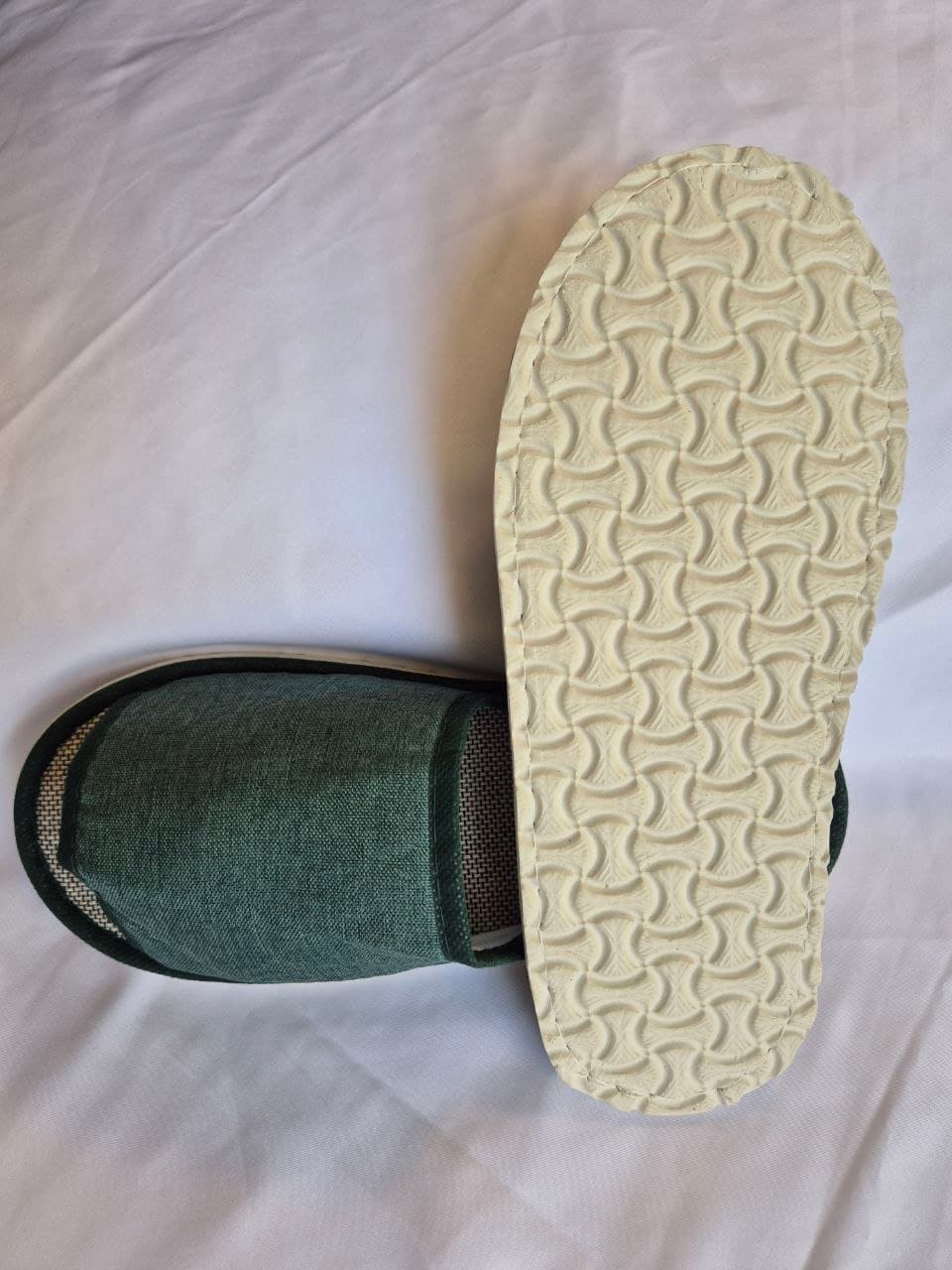 Linen hotel slippers near rattan basket