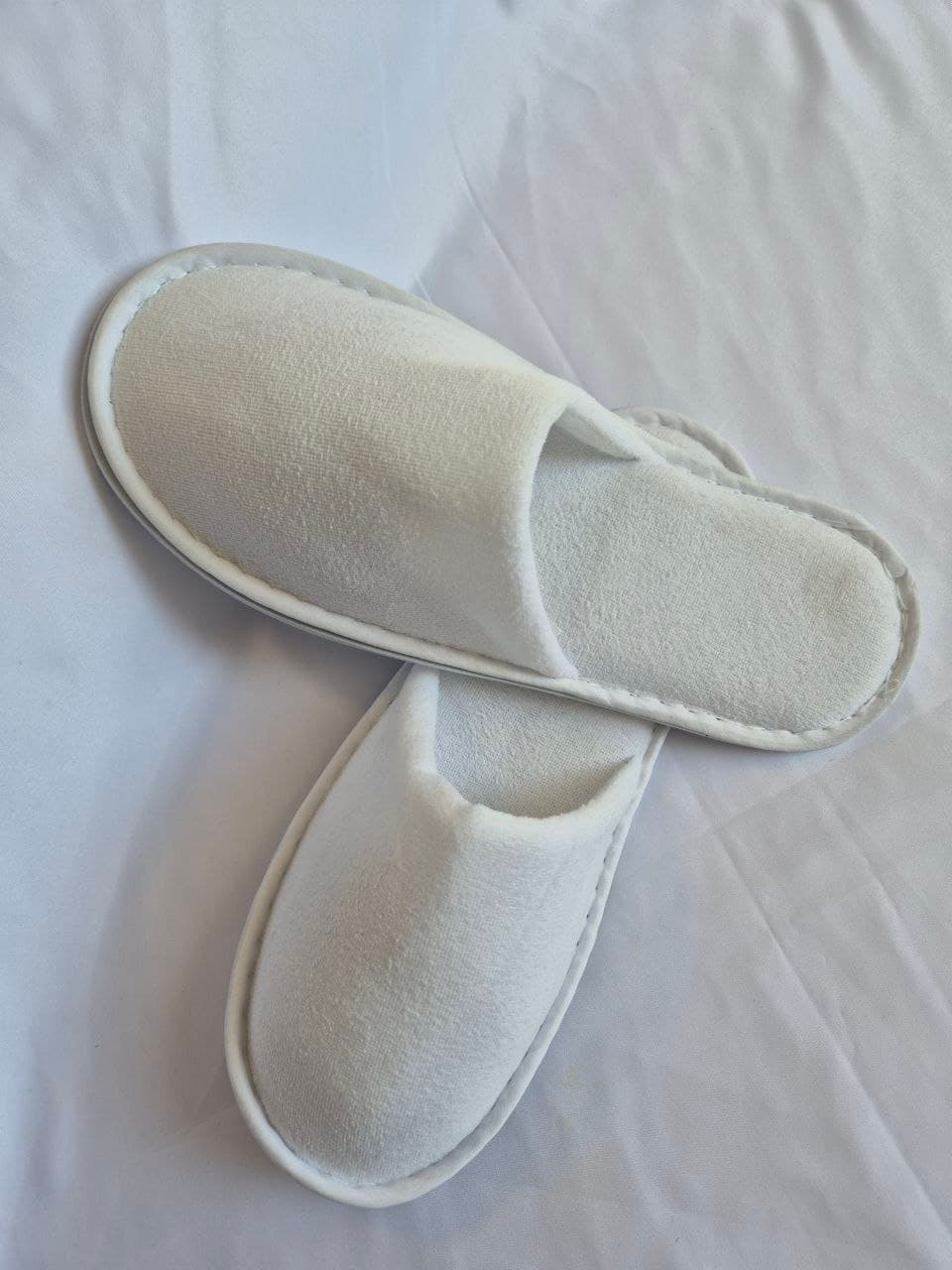 Coral fleece hotel slippers near rattan basket